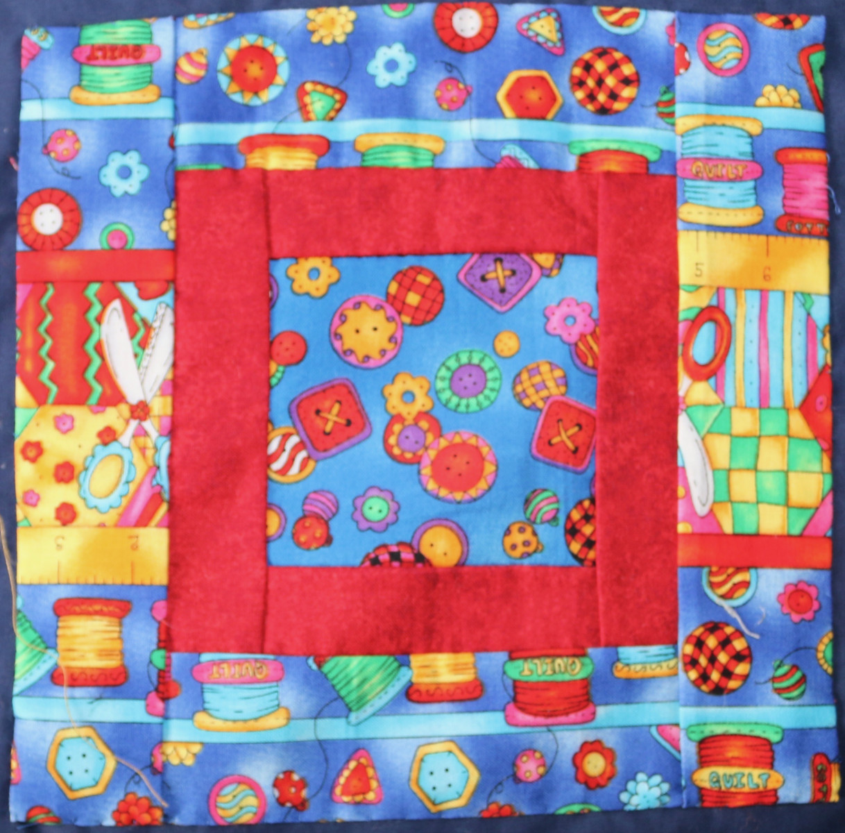 Patchwork square - material has images of cottons and buttons